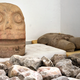 Uno de los cráneos hallados. Al fondo, la estatua de Xipe Topec